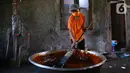 Pekerja mengaduk adonan dodol di pabrik dodol Betawi Mugi Jaya, Cilenggang, Tangerang Selatan, Rabu (13/5/2020). Produksi dodol selama pandemi Covid-19 tidak lebih dari 120 kg dibanding tahun lalu sebanyak 900 kg dodol. (Liputan6.com/Fery Pradolo)