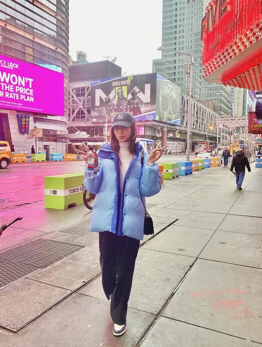Saat honeymoonn di New York City, Mikha juga tampil kasual dengan kaus putih dan celana hitam. Ia memberi tambahan puffer coat warna biru. [Foto: @miktambayong]