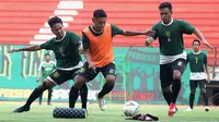 Pemain Persebaya berebut bola, Fandi Eko Utomo diapit oleh M. Hidayat dan Novan Sasongko dalam latihan di Stadio Gelora Bung Tomo, Surabaya, Rabu sore (27/3/2019). (Bola.com/Aditya Wany)