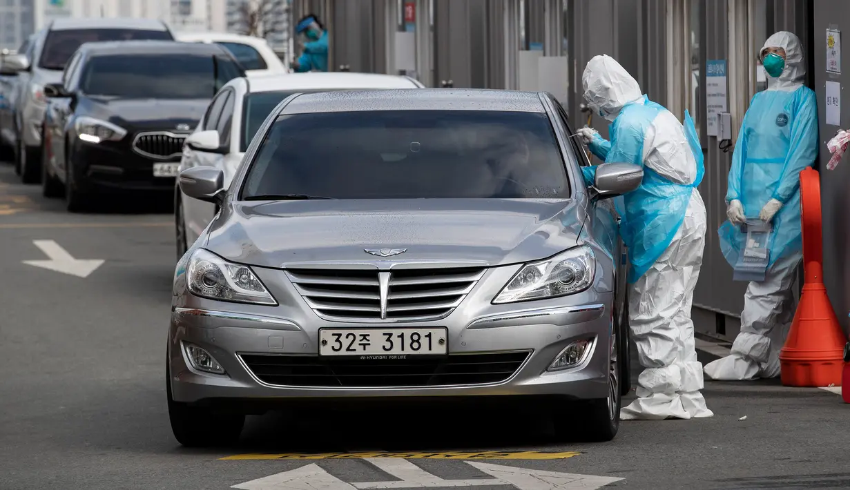 Pekerja medis Rumah Sakit Universitas Yeungnam melakukan pemeriksaan kesehatan di klinik drive-through atau tanpa turun dari kendaraan di Daegu, Korea Selatan, Rabu (4/3/2020). Jumlah kematian akibat virus corona (COVID-19) di Korea Selatan menjadi 33 orang. (Xinhua/Lee Sang-ho)