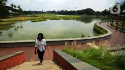Seorang wanita berjalan di Taman Mini Indonesia Indah (TMII) dengan wajah baru di Jakarta Timur, Rabu (16/11/2022). Pengelola TMII akan melakukan uji coba buka untuk umum pada 20 November 2022 dengan kuota 5000 orang selama berlangsung, dengan membeli tiket secara onlie di website TMII. (merdeka.com/Imam Buhori)