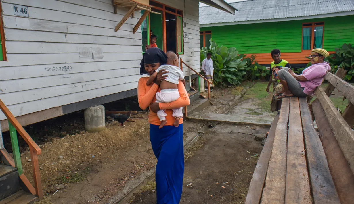 Pengungsi wanita menggendong anaknya di kompleks penampungan sementara Blang Adoe, Aceh Utara, Aceh, Rabu (27/4). Tersisa 300 orang pengungsi Rohingya di empat penampungan kabupaten/kota Pantai Utara dan Timur Aceh. (Chaideer Mahyuddin / AFP)