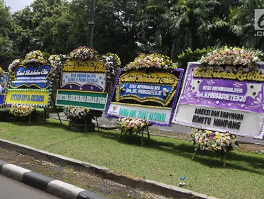 Warga mengambil gambar karangan bunga ucapan duka cita untuk Probosutedjo yang memenuhi Jalan Diponegoro, Jakarta, Senin (26/3). Probosutedjo meninggal dunia di RSCM Kencana Jakarta Pusat. (Liputan6.com/Arya Manggala)