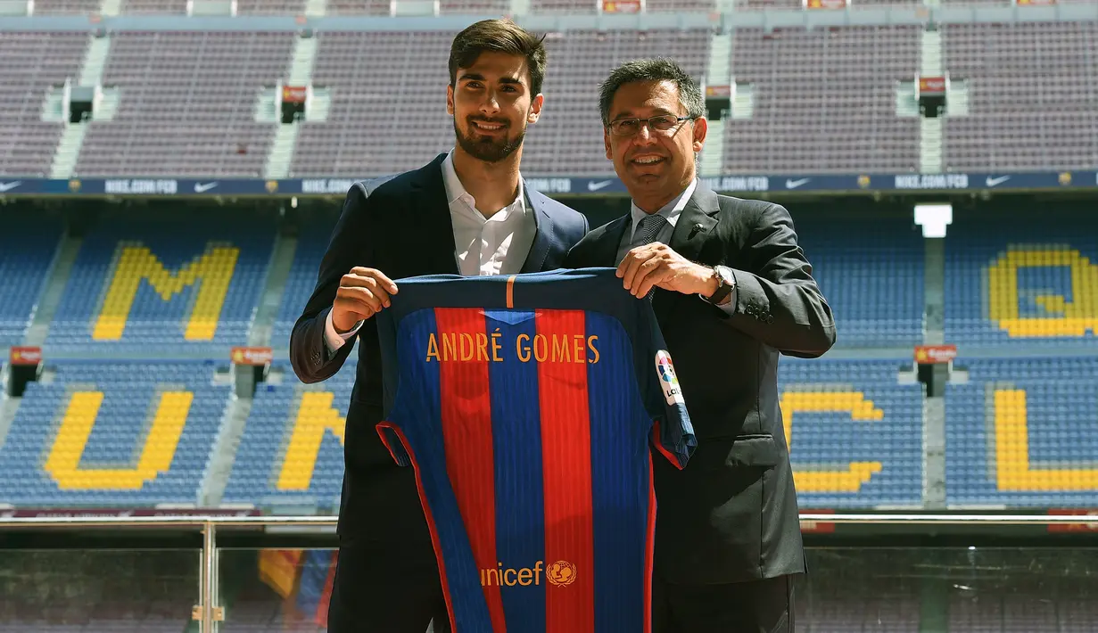 Pemain baru Barcelona, Andre Gomes (kiri) berfoto di samping Presiden Barcelona, Josep Maria Bartomeu saat diperkenalkan secara resmi di Camp Nou Stadium, Barcelona (27/7/2016). Andre Gomes didatangkan Barcelona dari Valencia pada awal musim 2016/2017 dengan nilai transfer sebesar 37 juta euro atau kini setara Rp595 miliar. Bertahan selama dua musim, ia total tampil dalam 78 laga di semua ajang dengan torehan 3 gol dan 4 assist. (AFP/Lluis Gene)