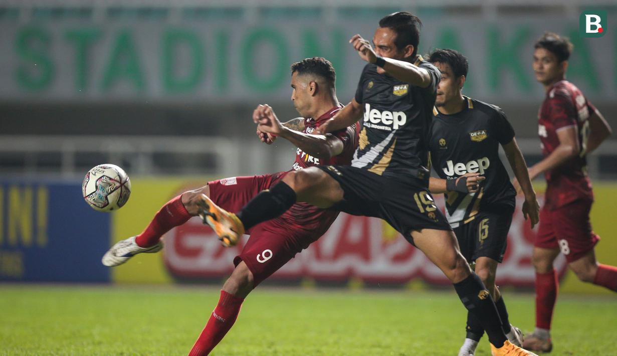 Pemain Persis Solo, Alberto Beto Goncalves (kiri) melepaskan tendangan yang berusaha diblok pemain Martapura Dewa United, Hery Susilo dalam laga semifinal Liga 2 2021 di Stadion Pakansari, Bogor, Senin (27/12/2021). (Bola.com/Bagaskara Lazuardi)