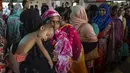 Seorang wanita menggendong anaknya saat mengantre membeli tiket menjelang Hari Raya Idul Adha 1440 H di sebuah stasiun kereta api di Dhaka (2/8/2019). Di Indonesia Idul Adha jatuh pada Minggu, 11 Agustus mendatang. (AFP Photo/Munir Uz Zaman)