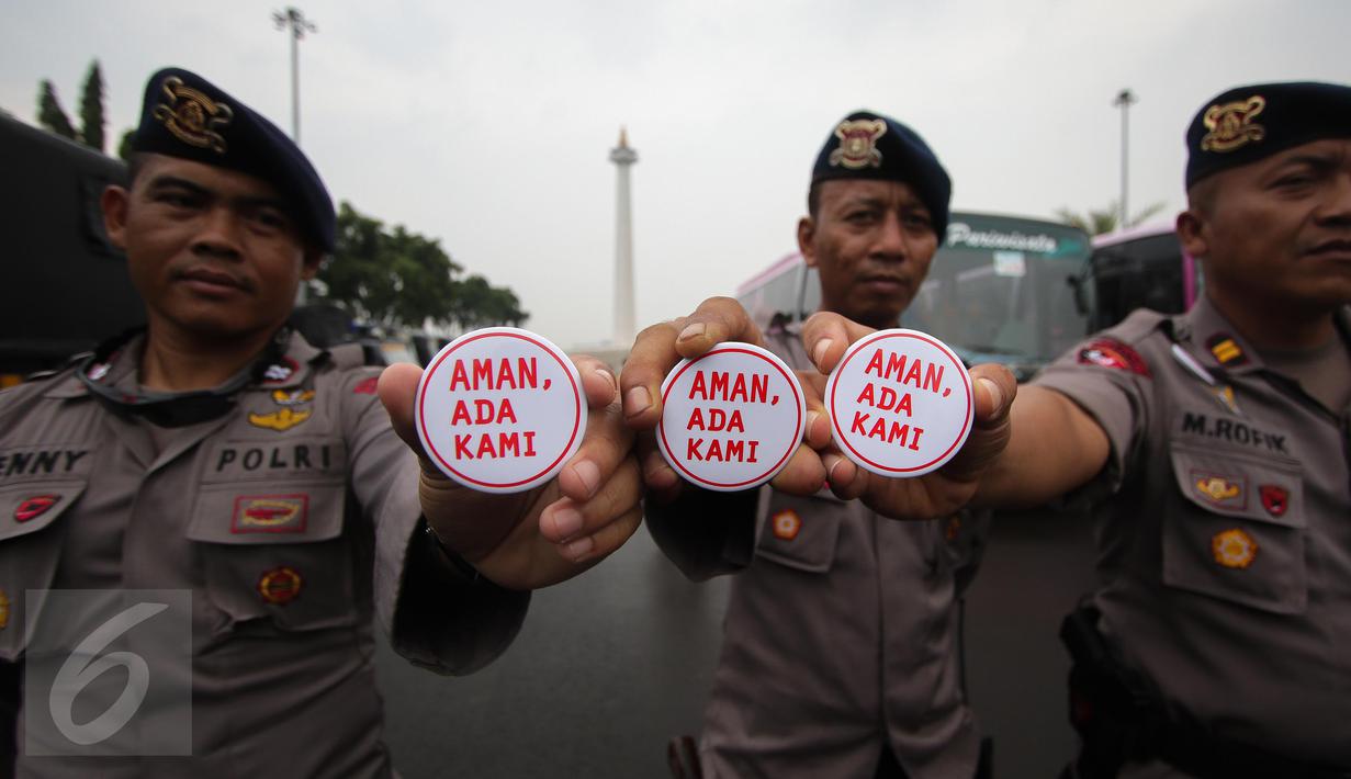 Petugas kepolisian menunjukan pin saat melakukan pengamanan di kawasan Monas, Jakarta, Selasa (18/4). Polda Metro Jaya dan Kodam Jaya mengerahkan 64.523 personel gabungan untuk mengawal Pilkada DKI 2017 putaran kedua. (Liputan6.com/Faizal Fanani)