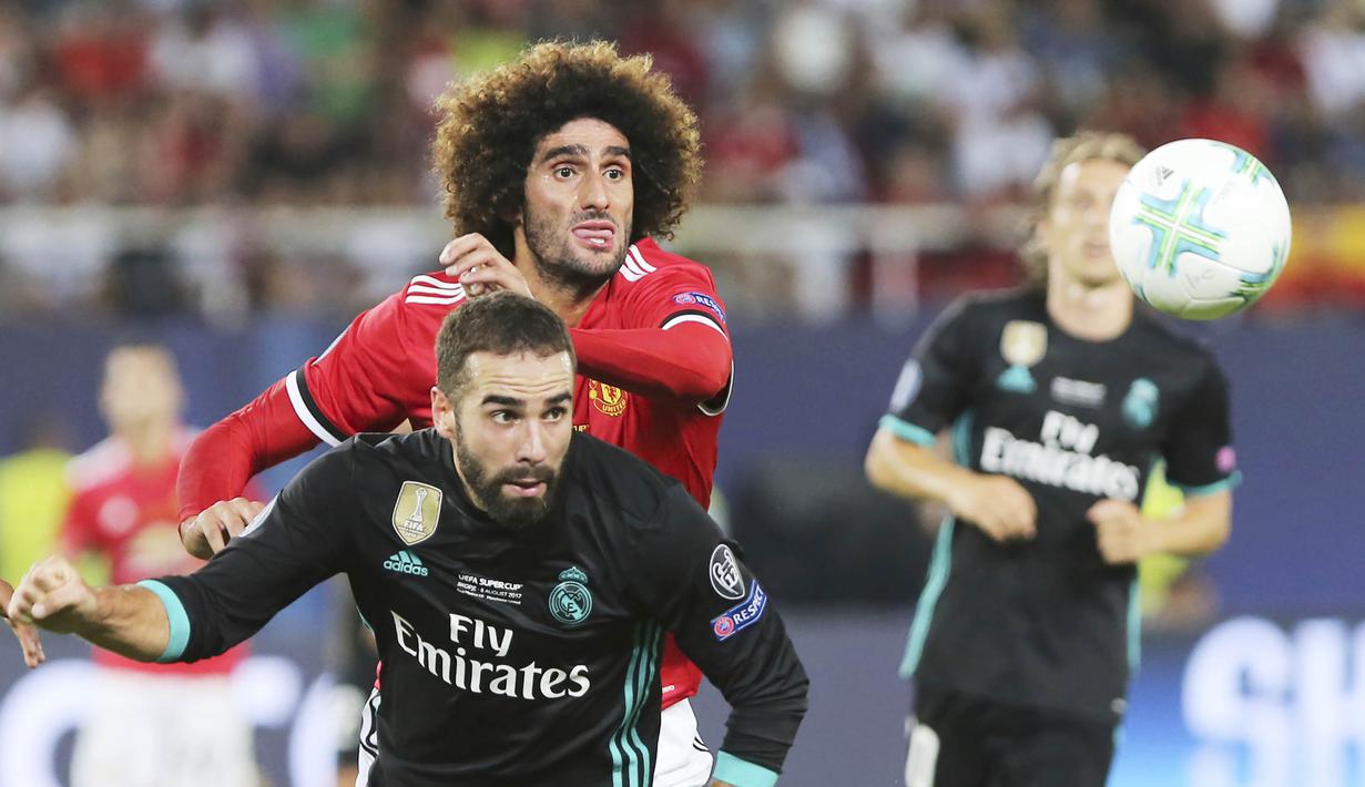 Gelandang Manchester United, Marouane Fellaini, berebut bola dengan bek Real Madrid, Daniel Carvajal, pada laga Piala Super Eropa di Stadion Philip II, Skopje, Selasa (8/8/2017). Foto muka unik Fellaini viral di dunia sosial. (AP/Boris Grdanoski)