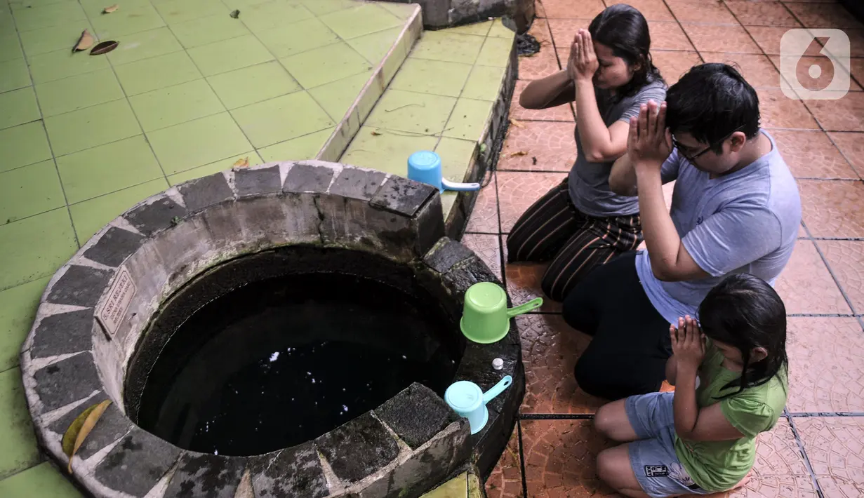 Warga keturunan Tionghoa memanjatkan doa di depan sumur sebelum membersihkan diri di Vihara Gayatri, Depok, Jawa Barat, Minggu (15/1/2023). Kemudian, Sri Kunaratih Kumadjaya agar enteng jodoh, Sri Rezeki guna usaha mencari rezeki, Dewi Sri Mulyasari untuk pengobatan, dan Sri Pontjo Warno guna menolak malapetaka. (merdeka.com/Iqbal S. Nugroho)