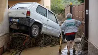 Seorang wanita mencoba membersihkan lumpur di Montemurlo dekat Prato setelah hujan deras semalam, pada 3 November 2023. (Federico SCOPPA/AFP)