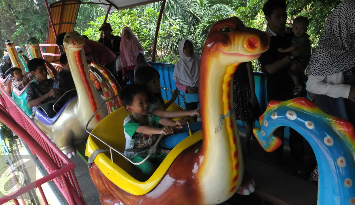 Sejumlah anak menaiki kereta mainan di Ragunan, Jakarta, Jumat (6/5). Tiket masuk yang murah menjadi alasan warga memilih Ragunan menjadi tempat liburan bersama keluarga. (Liputan6.com/Helmi Afandi)