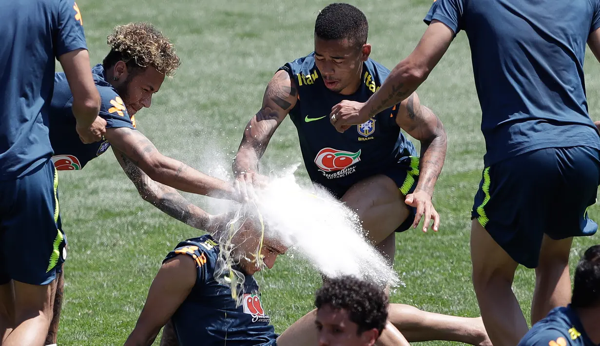 Momen saat pemain sepak bola Brasil, Neymar (kiri) dan Gabriel Jesus melempar tepung dan telur ke kepala Philippe Coutinho saat sesi latihan jelang Piala Dunia 2018 di Sochi, Rusia, Selasa (12/6). (AP Photo/Andre Penner)