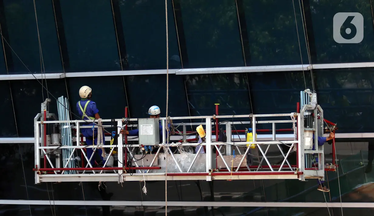 Pekerja melakukan perawatan gedung bertingkat di Jakarta, Rabu (28/7/2021). Menteri Koordinator Bidang Perekonomian Airlangga Hartarto mengungkapkan selain pekerja di wilayah PPKM Level 4, subsidi upah juga akan diberikan kepada pekerja di wilayah PPKM Level 3. (Liputan6.com/Angga Yuniar)