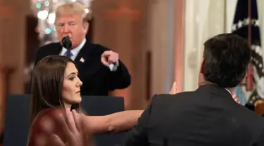 Presiden AS, Donald Trump mengarahkan telunjuk ke jurnalis CNN Jim Acosta saat seorang staf mencoba menarik mikrofon darinya dalam konferensi pers di Gedung Putih, Rabu (7/11). Ketegangan bermula dari pertanyaan sang wartawan soal imigran. (AP/Evan Vucci)