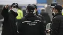 Petugas polisi mengenakan masker berbicara sebelum rapat umum di pusat kota Seoul, Korea Selatan, Sabtu (22/2/2020). Korsel pada hari Sabtu melaporkan lonjakan enam kali lipat infeksi virus dalam empat hari ke 346. (AP Photo/Lee Jin-man)