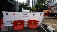 Kereta Commuter Line melintasi perlintasan KA Pejompongan 1 yang ditutup sementara, Jakarta, Rabu (12/4). Perlintasan KA Pejompongan 1 akan ditutup permanen pada 5 Mei mendatang. (Liputan6.com/Helmi Fithriansyah)