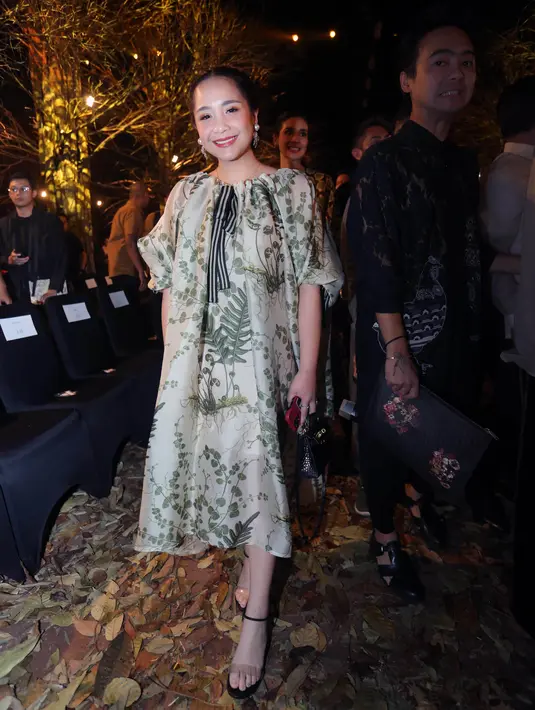 Nagita Slavina turut menghadiri gelaran fashion show tahunan Biyan. Tampil imut, Nagita Slavina memilih mengenakan rancangan Biyan, dress bermotif floral bernuansa kehijauan. Dress ini memiliki detail aksen balon di bagian lengan. Foto: Document/FIMELA.