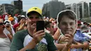 Seorang fan memegang topeng pembalap McLaren, Oscar Piastri dalam sesi latihan bebas Formula 1 GP Australia 2025 di Sirkuit Albert Park, Melbourne, Australia pada Jumat (14/03/2025). (AFP/Saeed Khan)