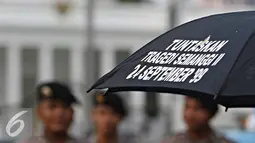 Petugas berjaga saat aksi Kamisan ke-436 di Jakarta, Kamis (24/3). Aksi sekaligus memperingati Hari Internasional untuk Hak atas Kebenaran Terkait Pelanggaran HAM Berat dan Martabat Korban yang jatuh pada 24 Maret. (Liputan6.com/Immanuel Antonius)