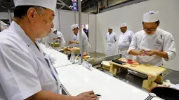 Seorang juri (kiri) memeriksa sushi buatan para peserta pada World Sushi Cup Japan 2016 di Tokyo, Kamis (18/8). 27 koki dari 14 negara mengikuti kompetisi membuat sushi ini. (Toru Yamanaka / AFP)