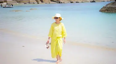 Dine Mutiara tampil memesona dengan memakai pakaian kuning saat liburan di pantai. Gaya kecenya yang curi perhatian ini banjir like dan komentar dari netizen. Ia disebut menawan dan beruntung Sahrul dapat istri seperti Dine. (Liputan6.com/IG/dine.pearl)