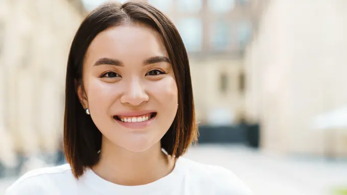 perempuan tersenyum bahagia baju putih