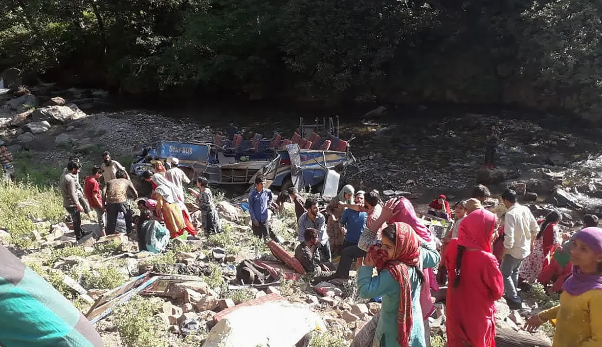 Tim penyelamat dibantu warga mengevakuasi korban kecelakaan bus di di wilayah Kishtwar di negara bagian Jammu dan Kashmir (1/7/2019). Menurut pejabat setempat, Angrez Singh Rana bus tergelincir di jalan berkelok di distrik Kisthwar. (AFP Photo/STR)