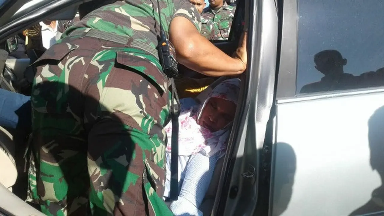 petugas memeriksa kondisi penumpang mobil yang diduga keracunan gas emisi.