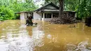 Warga di distrik-distrik tersebut diimbau untuk tetap waspada, menghindari perjalanan yang tidak perlu, dan bersiap untuk evakuasi segera. Tampak dalam foto, seorang pria mengarungi banjir di luar rumahnya setelah hujan deras di Kaduwela, pinggiran Kolombo, pada Jumat 28 November 2025. (Ishara S. KODIKARA/AFP)