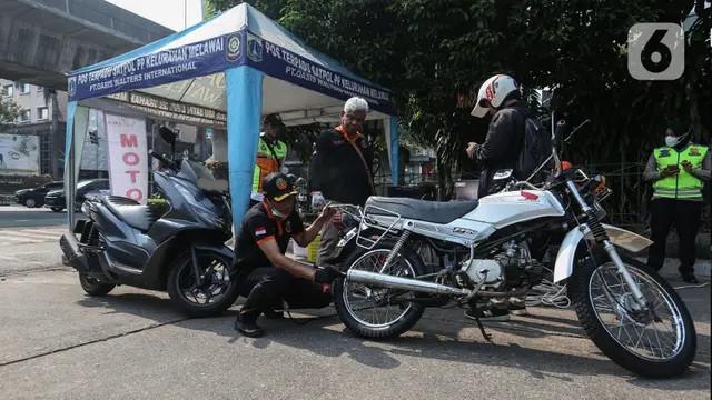 Petugas melakukan uji emisi kendaraan (Liputan6.com/Johan Tallo)