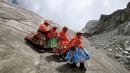 Perempuan suku Aymara mendaki Gunung Huayna Potosi, Bolivia (6/4). Sebanyak 12 perempuan Suku Aymara rata-rata berusia 42-50 tahun ini berhasil menaklukkan puncak Gunung Huayna Potosi dan Illimani. (REUTERS/David Mercado)
