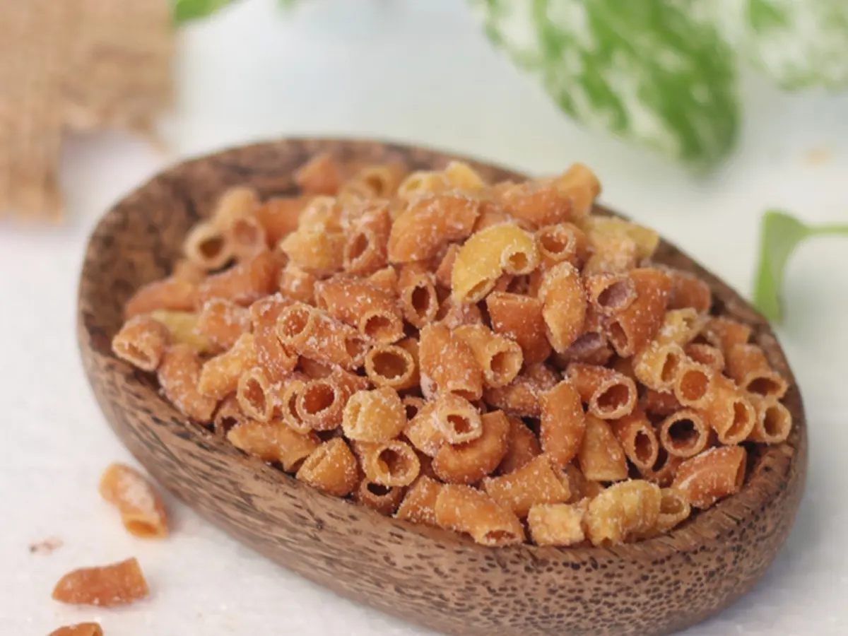 sepiring makaroni goreng renyah yang disajikan dengan taburan bubuk keju dan cabai