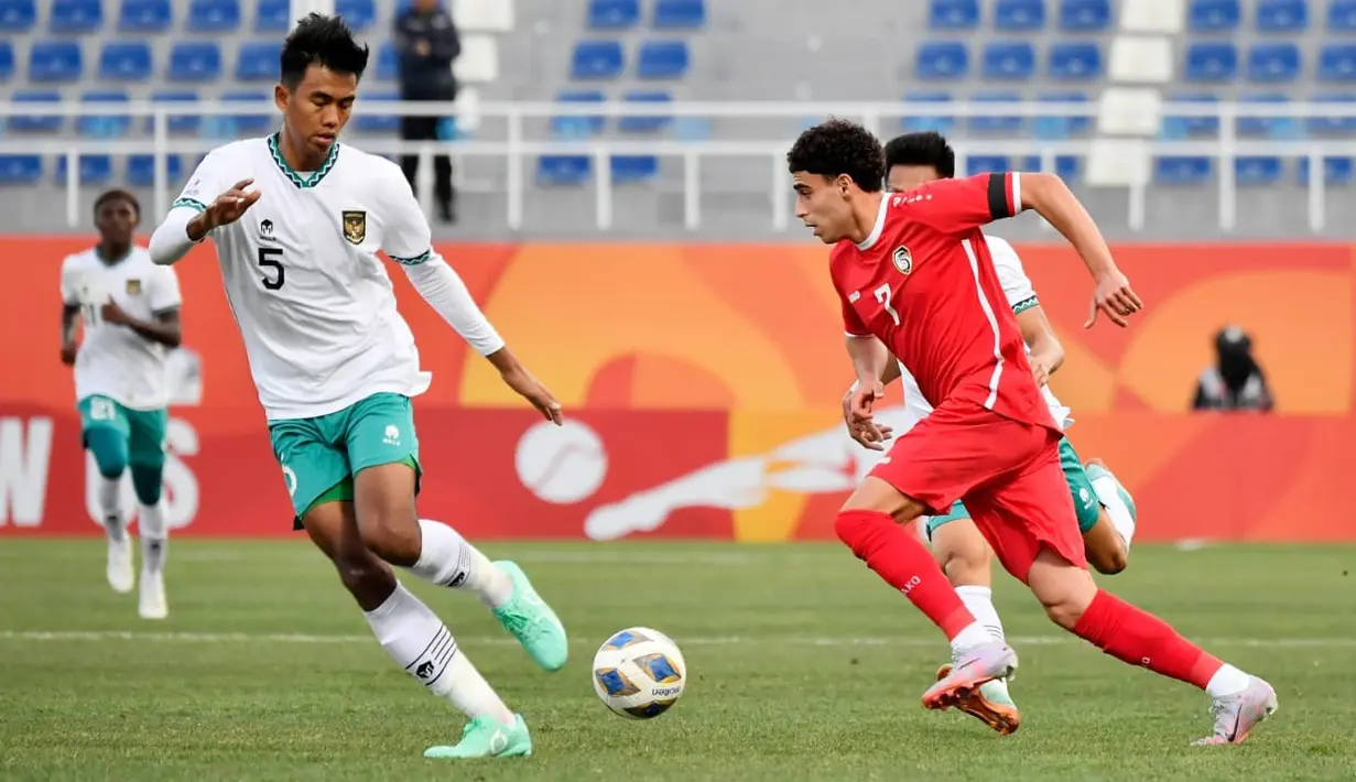 Pemain Timnas Indonesia U-20 Kakang berebut bola dengan pemain Suriah U-20 Hozan Rawan pada laga matchday kedua Grup A Piala Asia U-20 2023 di Lokomotiv Stadium, Tashkent, Uzbekistan, Sabtu (4/3/2023). Suriah terus mengurung lini pertahanan Timnas Indonesia U-20 hingga laga tuntas, tapi tidak berbuah hasil. (FOTO: Dok. PSSI)
