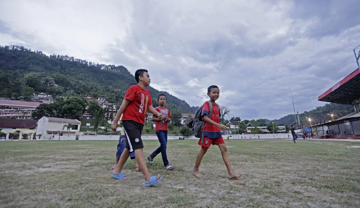 Anak-anak SSB PS TAL Sawahlunto berjalan pulang setelah mengikuti latihan di Stadion Tanah Lapang Ombilin, Sawahlunto, (8/11/2016). (Bola.com/Nicklas Hanoatubun)