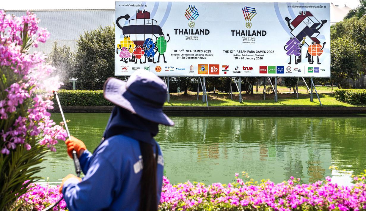 SEA Games 2025 Thailand, yang akan berlangsung pada 9-20 Desember, secara total akan mempertandingkan 50 cabang olahraga dengan 105 disiplin dan 569 nomor. Tampak dalam foto, aktivitas pekerja kebun menyiram tanaman di dekat papan reklame SEA Games 2025 di luar Stadion Nasional Rajamangala, Bangkok, Thailand pada Jumat 28 November 2025. (Chanakarn Laosarakham/AFP)