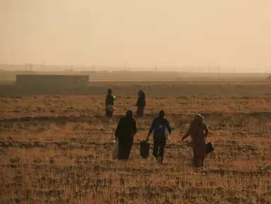 Warga melarikan diri dengan berjalan kaki saat pasukan Turki memburu milisi Kurdi di Ras al Ayn, Suriah, Rabu (9/10/2019). Presiden Turki Recep Tayyip Erdogan mengumumkan dimulainya operasi militer terhadap milisi Kurdi di timur laut Suriah. (AP Photo/Baderkhan Ahmad)