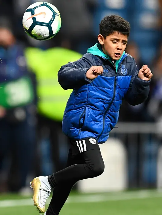 Aksi putra Cristiano Ronaldo, Cristiano Ronaldo Jr saat menunjukkan kebolehannya mengontrol bola usai pertandingan antara Real Madrid dan Real Sociedad di stadion Santiago Bernabeu di Madrid, Spanyol (10/2). (AFP Photo/Gabriel Bouys)