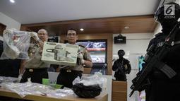 Kepala Divisi Humas Mabes Polri Inspektur Jenderal Pol Setyo Wasisto (tengah) menunjukan barang bukti yang berhasil diamankan  saat gelar rilis Pengungkapan Kasus Teroris dan Gelar BB di Divhumas Polri, Jakarta, Kamis (22/6). (Liputan6.com/Faizal Fanani)