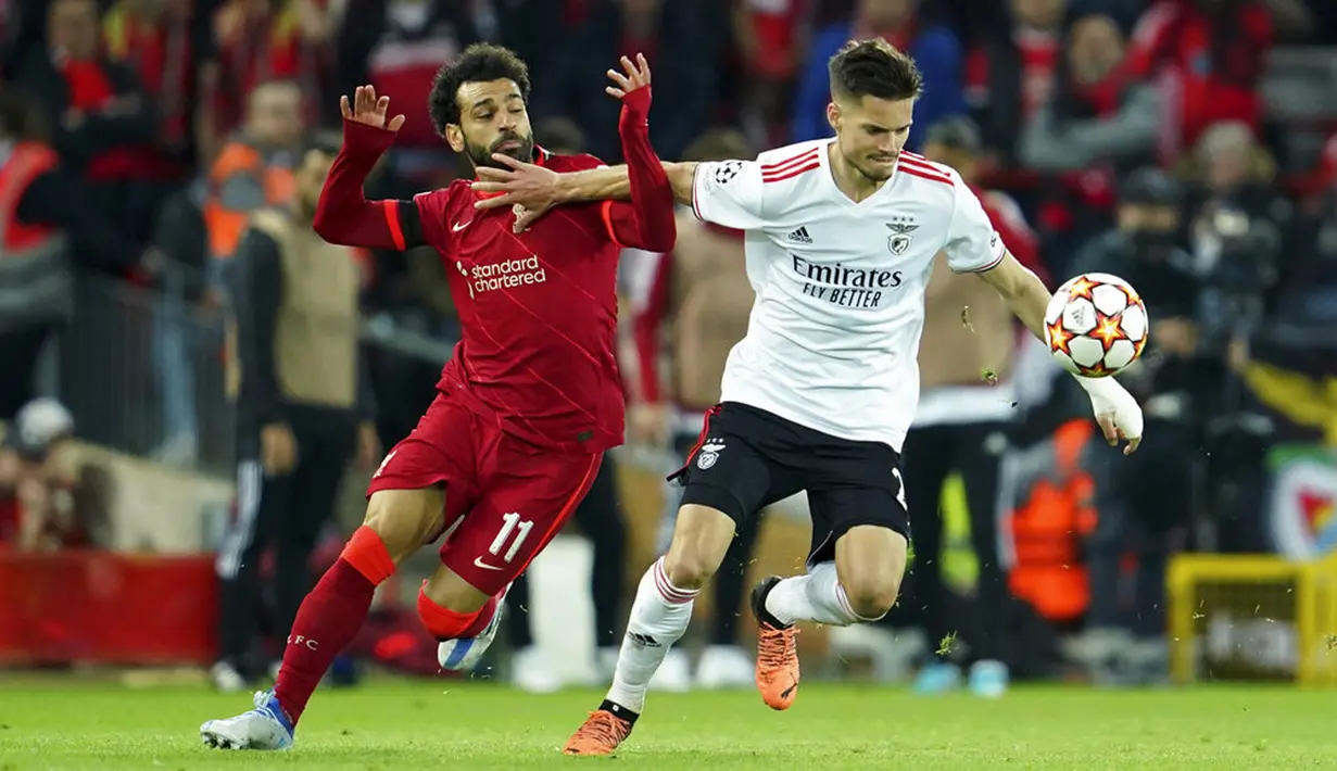Pemain Liverpool Mohamed Salah (kiri) berebut bola dengan pemain Benfica Julian Weigl pada pertandingan sepak bola leg kedua perempat final Liga Champions di Stadion Anfield, Liverpool, Inggris, 13 April 2022. Pertandingan berakhir dengan skor 3-3. (AP Photo/Jon Super)