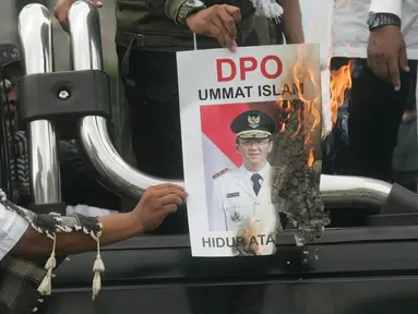 Massa dari ormas Islam se- DIY membakar foto Gubernur DKI Jakarta saat tabligh akbar di Titik Nol km, Yogya, Minggu (9/10). Mereka mendukung PP Muhammadiah yang telah melaporkan Ahok ke Polda Metro Jaya atas penistaan agama. (Liputan6.com/ Boy Harjanto)