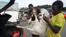 Seorang pria memasukkan domba, untuk perayaan Idul Adha, ke dalam mobil di sebuah pasar kawasan Abidjan, Pantai Gading, Jumat (17/8). Umat Islam di seluruh dunia akan merayakan Hari Raya Idul Adha yang identik dengan tradisi berkurban. (AFP/ISSOUF SANOGO)