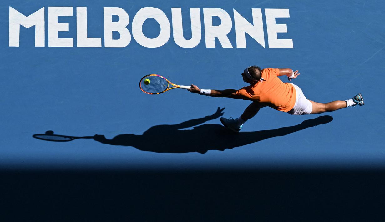 Petenis Spanyol, Rafael Nadal mengembalikan bola ke arah petenis Inggris, Jack Draper saat laga hari pertama Australian Open 2023 di Melbourne, Australia, Senin (16/01/2023). (AFP/Manan Vatsyayana)