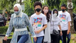 Mantan Anggota DPR Angelina Sondakh (kiri) bersama kedua anaknya Aaliyah Massaid dan Keanu Jabbar Massaid saat ziarah makam di TPU Jeruk Purut, Jakarta Selatan, Kamis (3/3/2022). Kedatangan mereka untuk berziarah ke makam Adjie Massaid dan bapak dari Adjie Massaid. (Liputan6.com/Herman Zakharia)