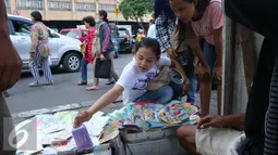 Calon pembeli memilih kartu ucapan selamat Idul Fitri di Tanah Abang, Jakarta, Selasa (28/6). Penjualan kartu ucapan tersebut alami penigkatan 100% karena menjadi incaran masyarakat untuk melengkapi hari raya lebaran. (Liputan6.com/Angga Yuniar)