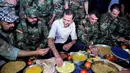 Presiden Suriah Bashar al-Assad dan pasukan setianya melahap hidangan buka puasa di Desa Marj al-Sultan, timur Ghouta, Damaskus, Suriah, Minggu (26/6). (REUTERS/Sana)