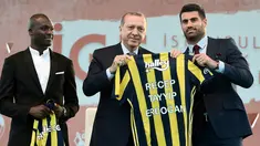 Presiden Turki, Recep Tayyip Erdogan (tengah) memegang jersey atas namanya ditemani pesepak bola dari Fenerbahce, Mousa Sow (kiri) dan Volkan Demirel (kanan) saat menghadiri Istanbul Youth Festival di Istanbul, Turki, Kamis (4/5). (AFP PHOTO / OZAN KOSE)