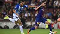 Bek Malaga, Luis Hernandez, mencoba menahan laju gelandang Barcelona, Sergi Roberto, pada laga La Liga di Stadion Camp Nou, Barcelona, Sabtu (21/10/2017). Barcelona menang 2-0 atas Malaga. (AFP/Josep Lago)