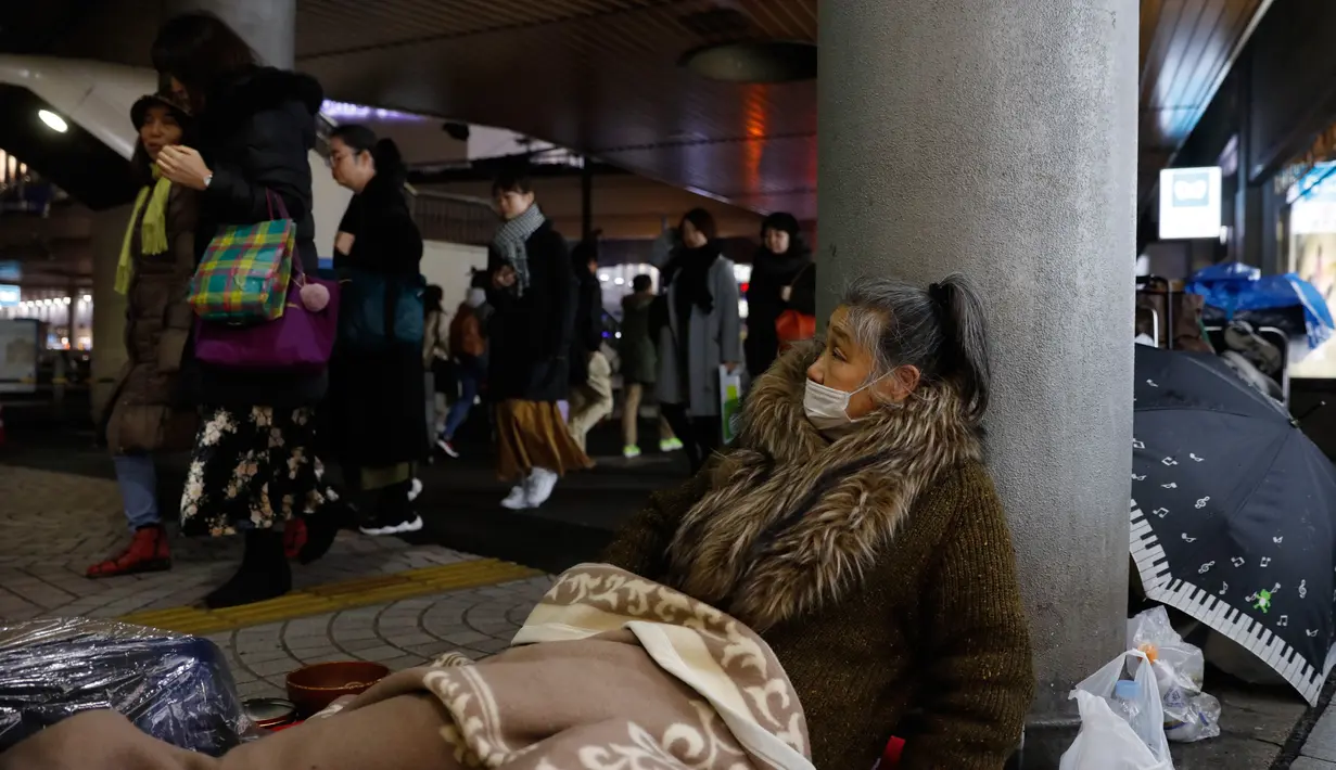 Seorang tunawisma duduk mengemis di trotoar luar Stasiun Shinjuku, Tokyo, Jepang, Selasa (7/1/2020). Seperti Amerika Serikat, Jepang memiliki tingkat kemiskinan yang relatif tinggi untuk negara kaya. (AP Photo/Jae C. Hong)