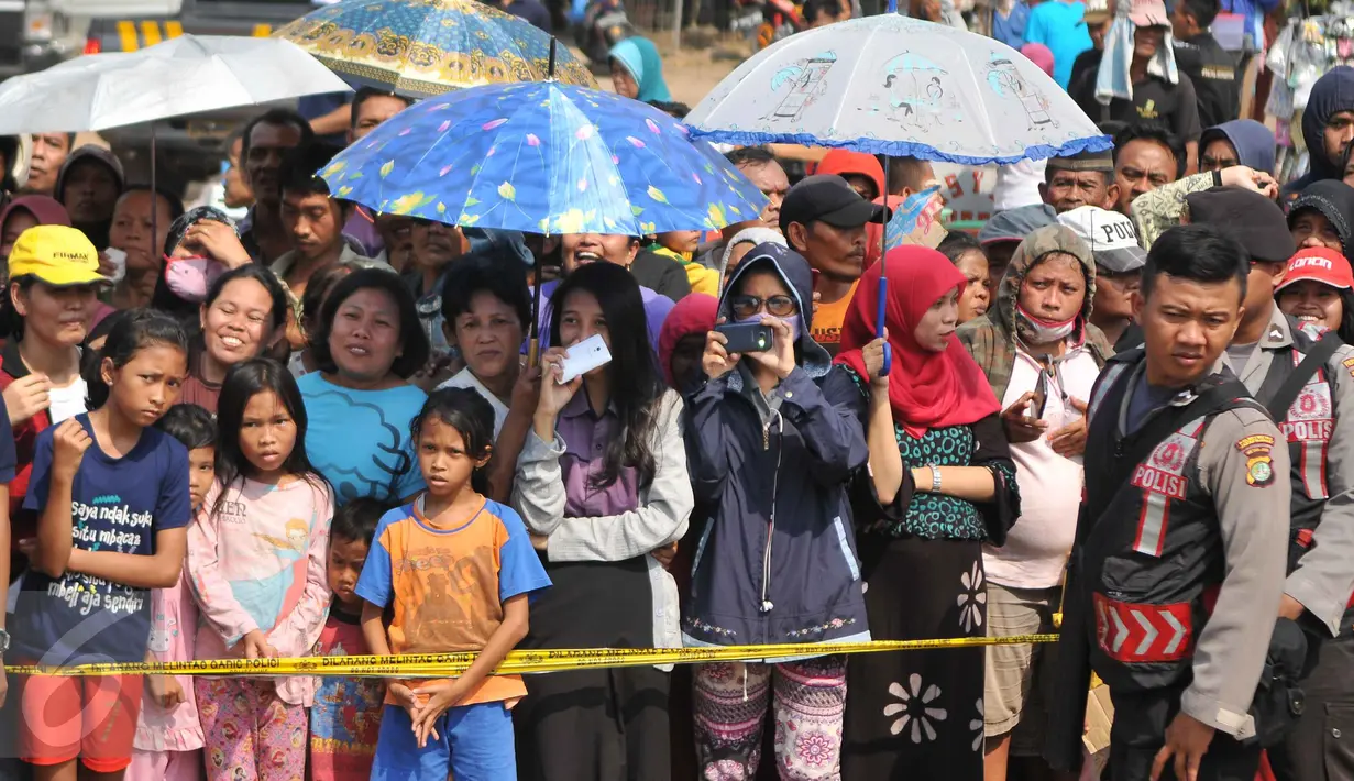 Sejumlah warga melihat reka ulang pembunuhan bocah dalam kardus, Jakarta, Selasa (20/10/2015). Proses rekonstruksi dengan tersangka Agus Dermawan menjadi tontonan warga. (Liputan6.com/Gempur M Surya)