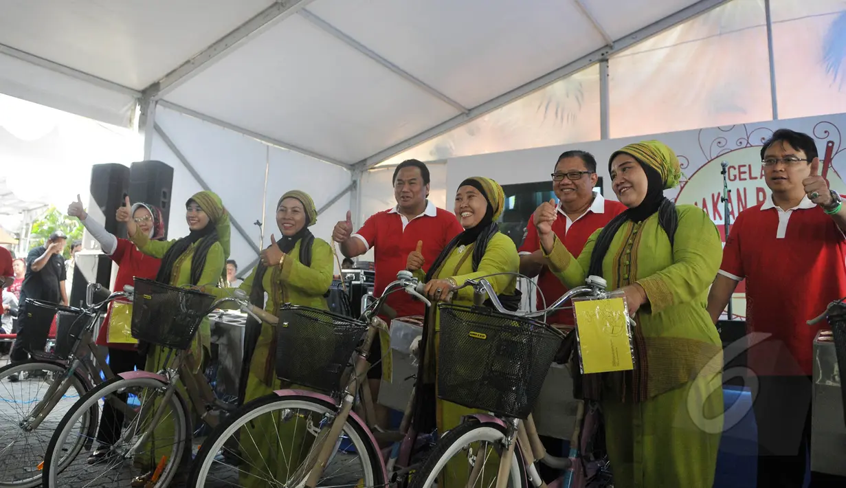 Mendag Rahmat Gobel dan Menteri ‎Koperasi dan UKM Anak Agung Gede Ngurah Puspayoga bersama penjual jamu saat menghadiri Peringatan Hari Konsumen Nasional, Lapangan Parkir Gedung Sarinah, Jakarta, Minggu (10/5/2015). (Liputan6.com/Herman Zakharia) 